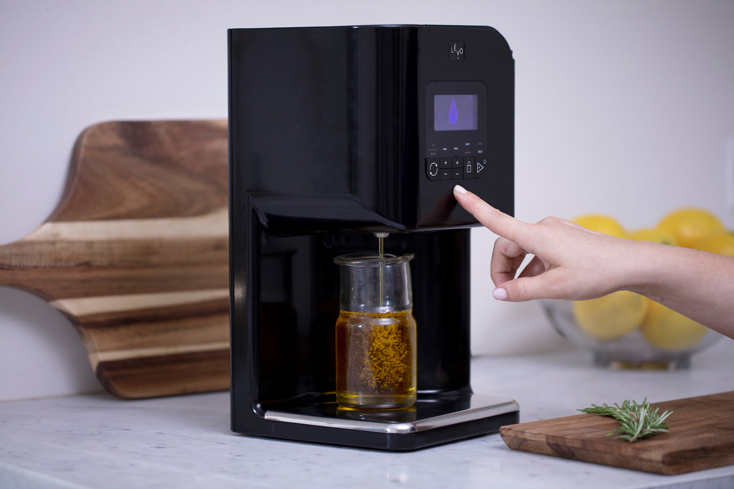 Image of a person using a LEVO II device to learn how to infuse olive oils.