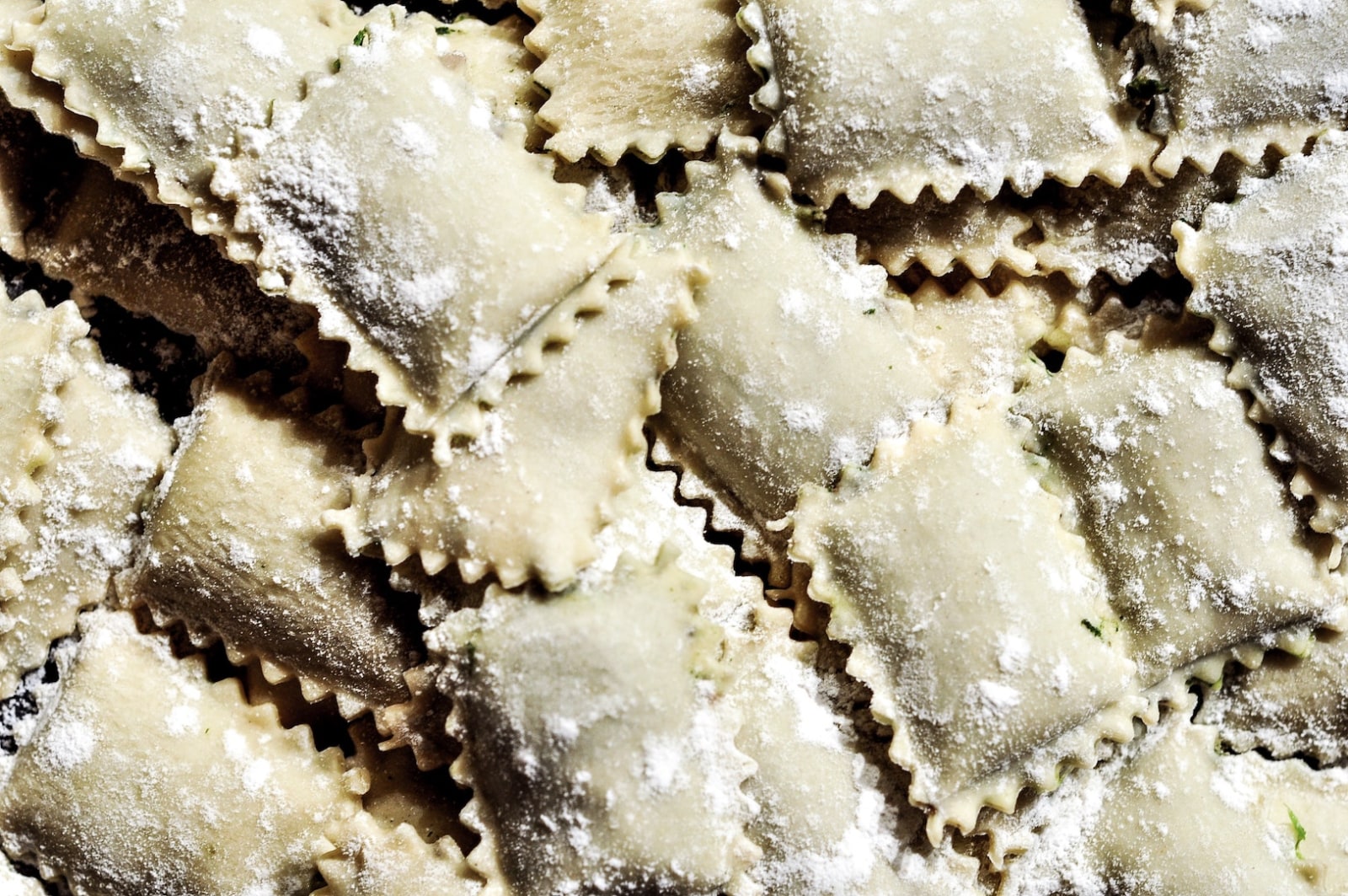 Image of uncooked ravioli on a countertop. Make your own with our ravioli recipe with ricotta.