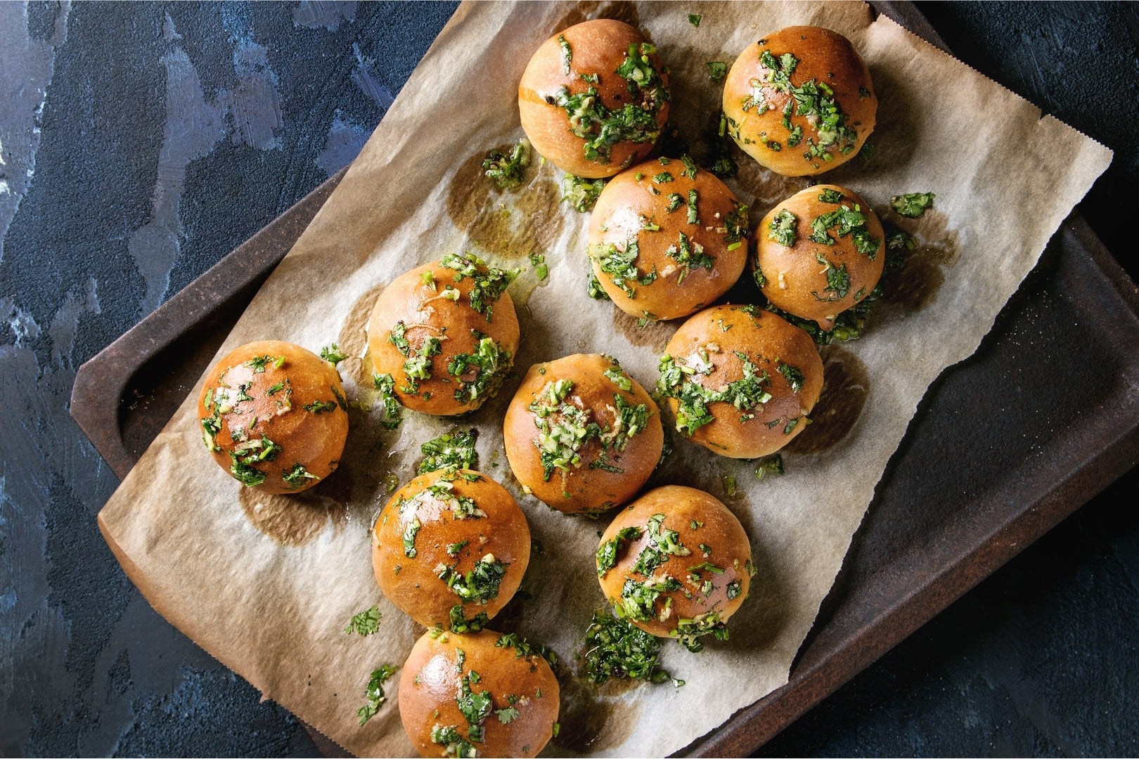  Golden Garlic Rolls placed on a pan, baked with garlic infused oil and sprinkled with parsley