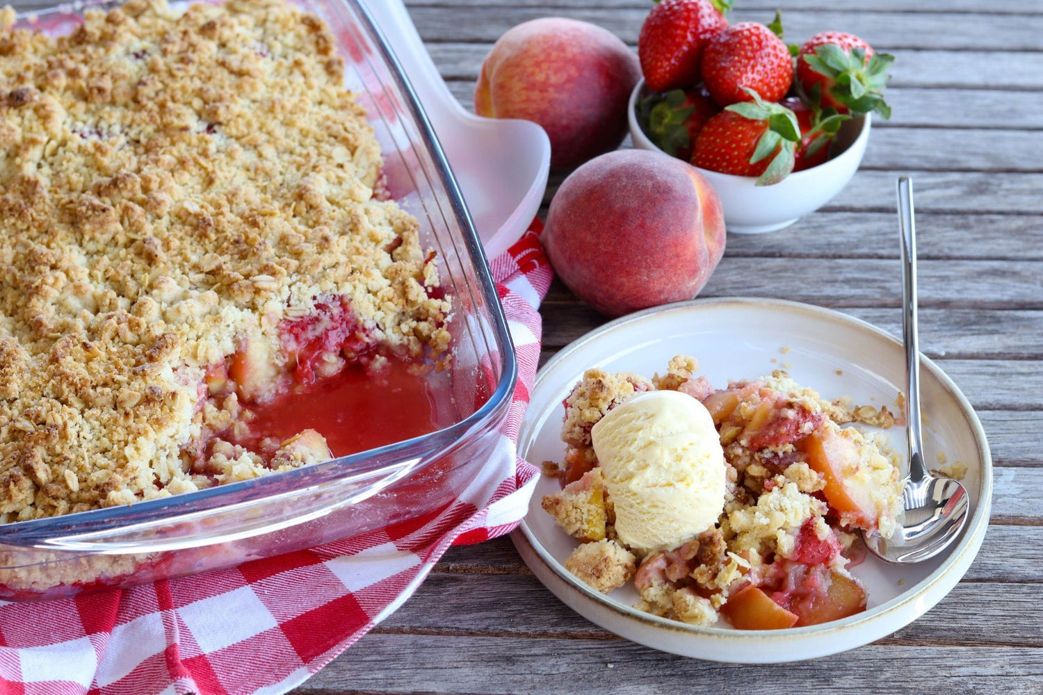 Strawberry and Peach crisp put in a bowl, served with Ice cream