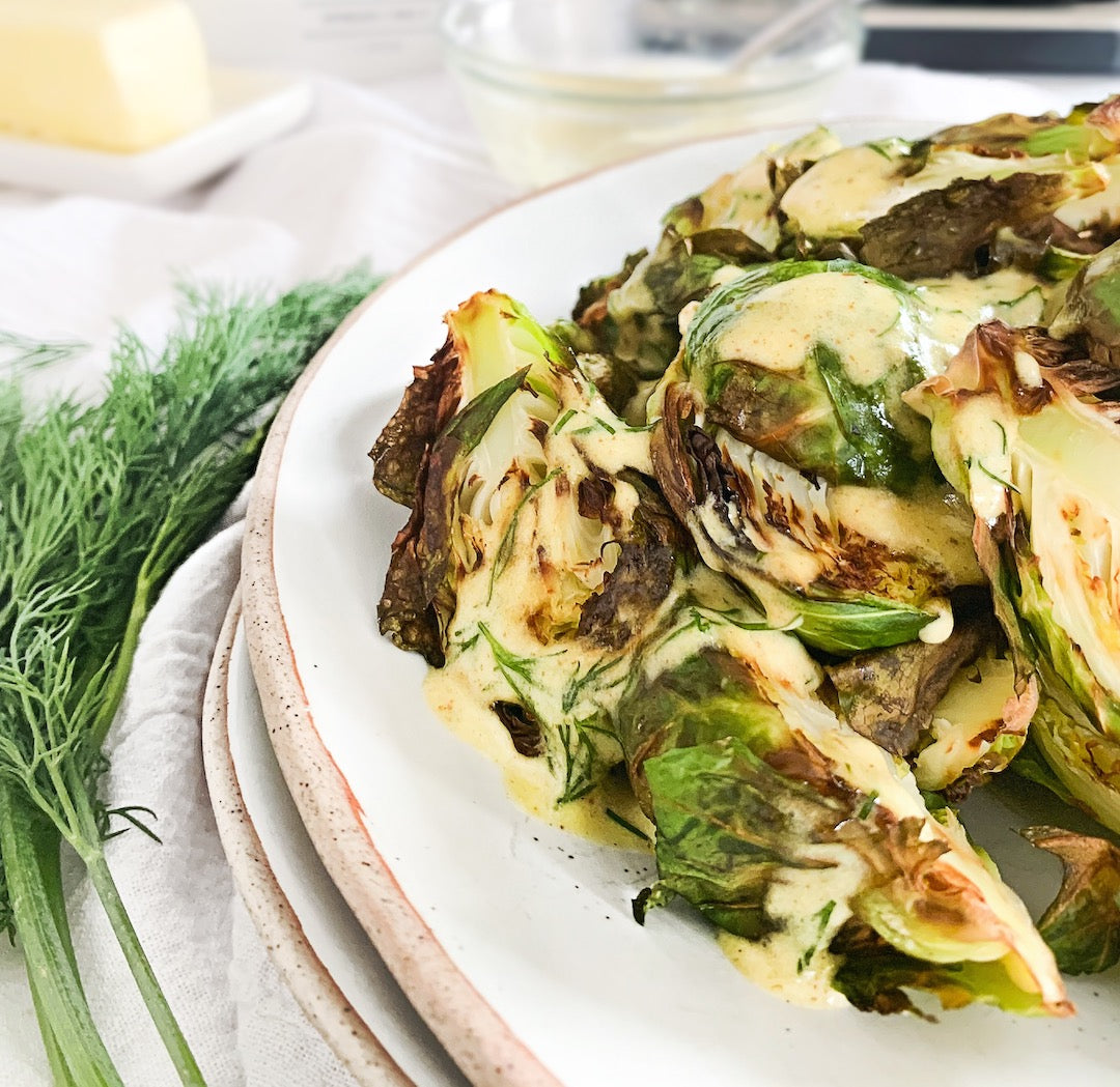 Image of creamy dill mustard sauce on a plate of brussels sprouts.