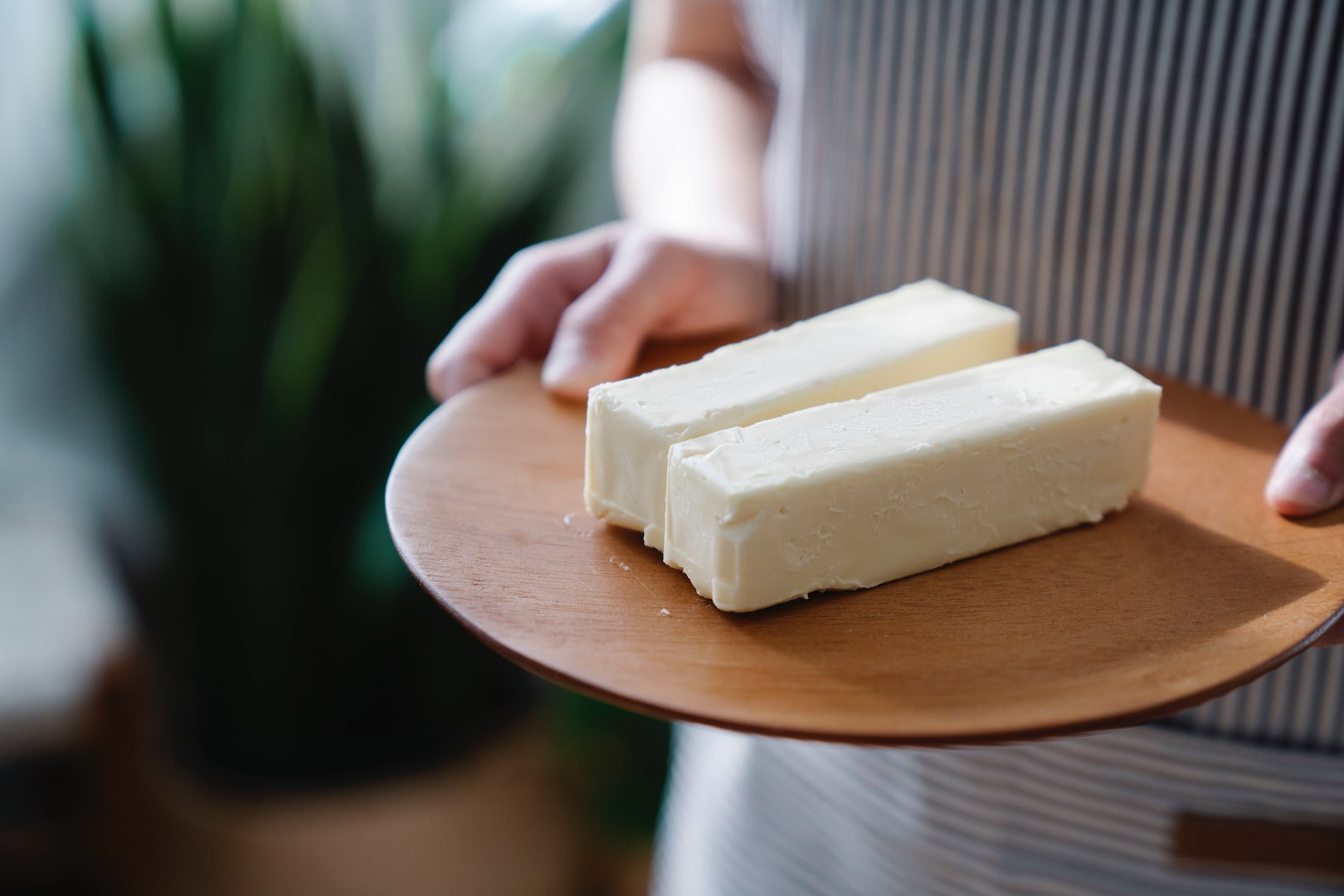 Image of person holding two blocks of cheese. Does butter go bad? Learn more with LĒVO.