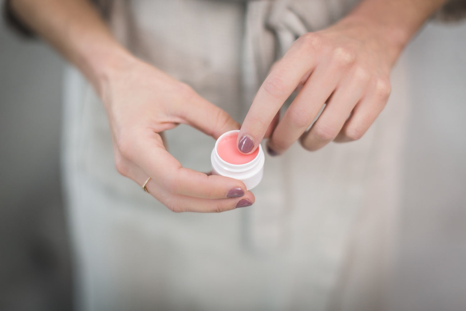 Image of person holding DIY lip balm made by LĒVO.