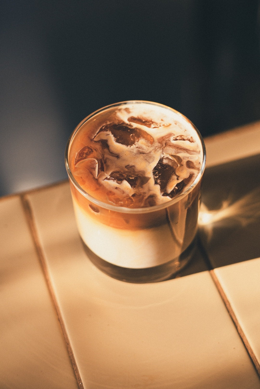 Image of an iced vanilla oat milk latte on a table made by the LEVO team.