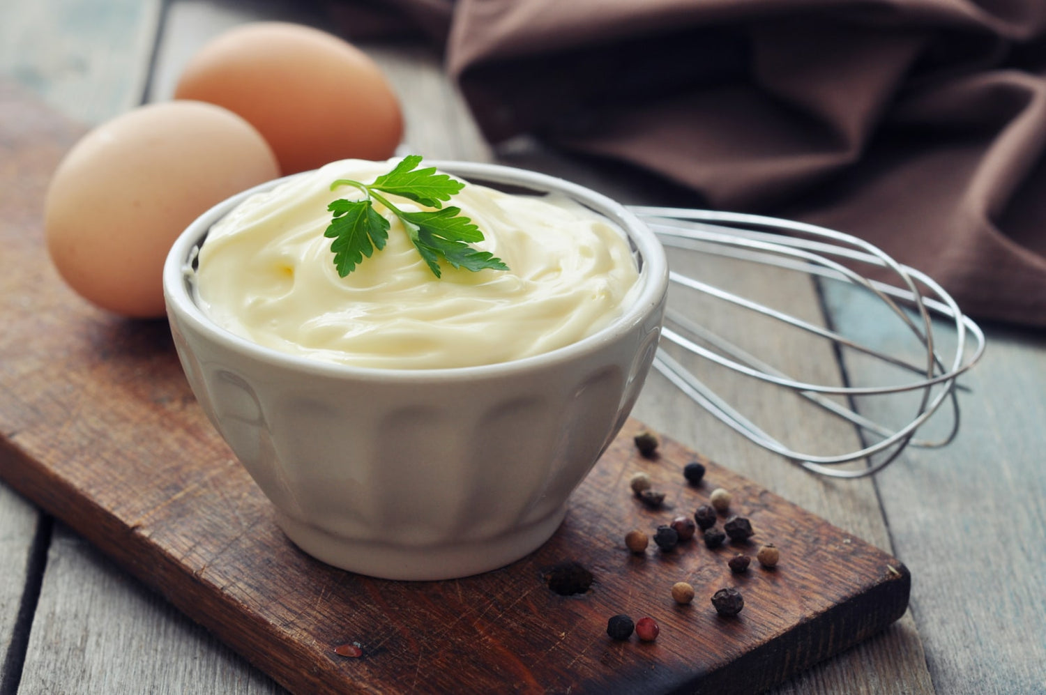 Image of infused mayo in a bowl next to eggs and a mixer. Made with LĒVO.