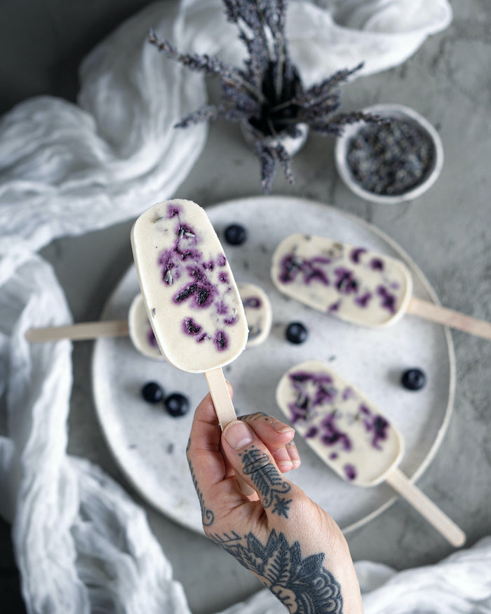 Image of a person holding blueberry lavender popsicles.