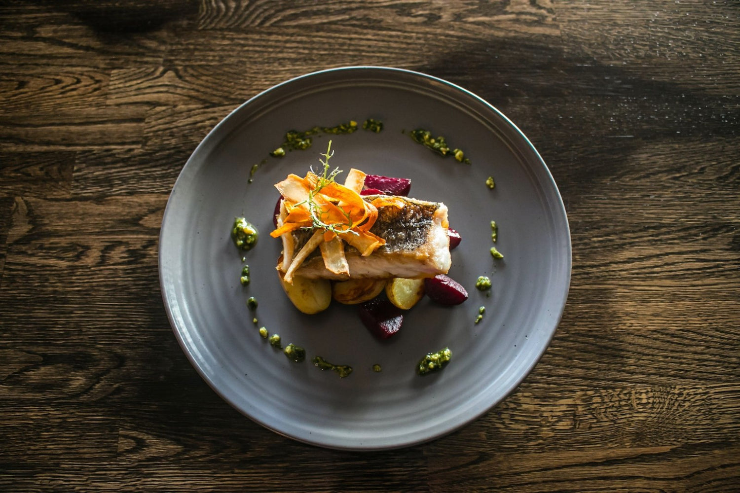 Image halibut on a plate. Make your own by following LĒVO's infused oven baked halibut recipe.