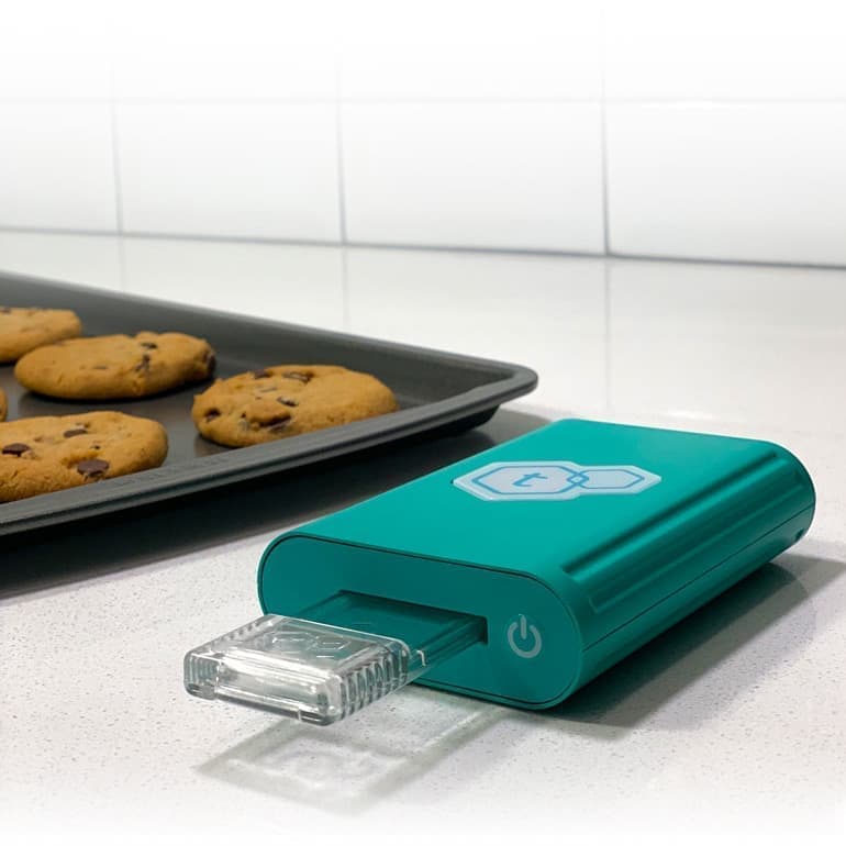 The tCheck device in use next to LEVO infused cookies. LĒVO C and tCheck Potency Tester: Master the art of infusion and potency.