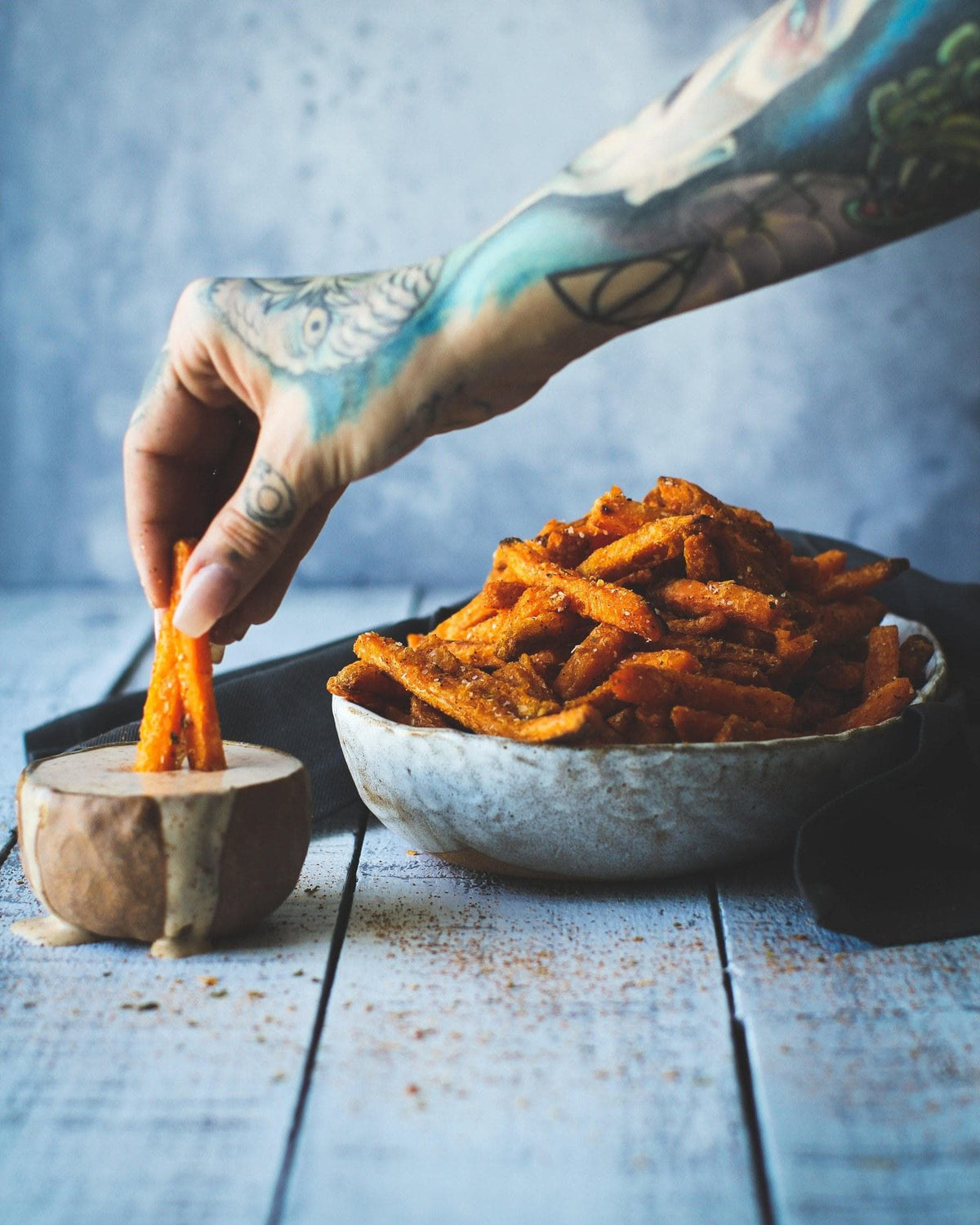 Hands dipping a snack into a homemade sauce
